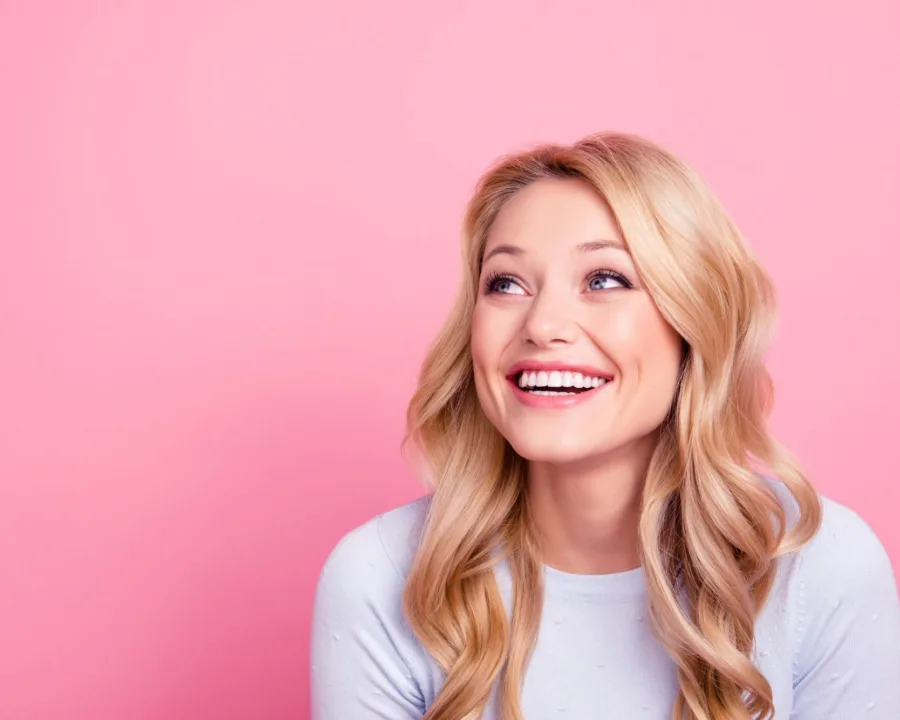 Patient smiling after getting their braces off with no white spots on their teeth.