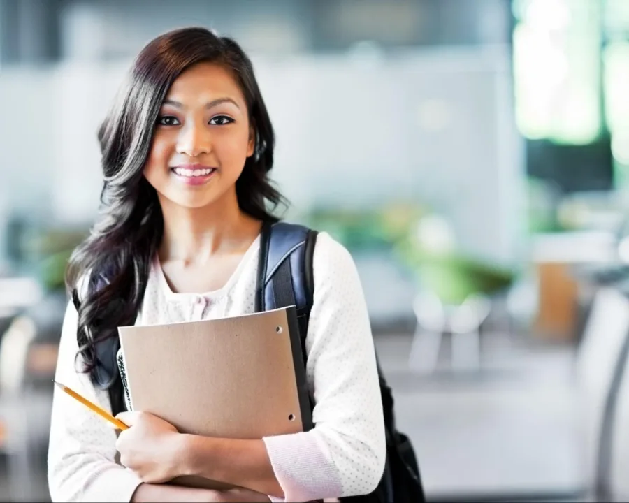 A student with clear aligners holding a notebook.