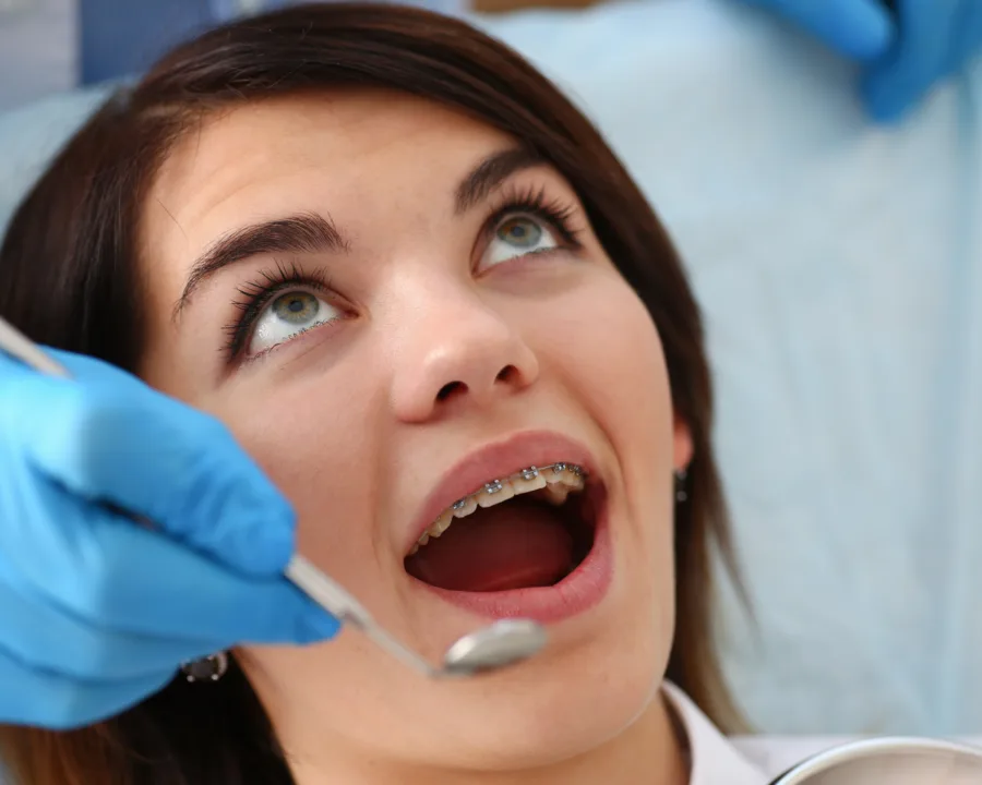 Patient getting their braces checked by the orthodontist.