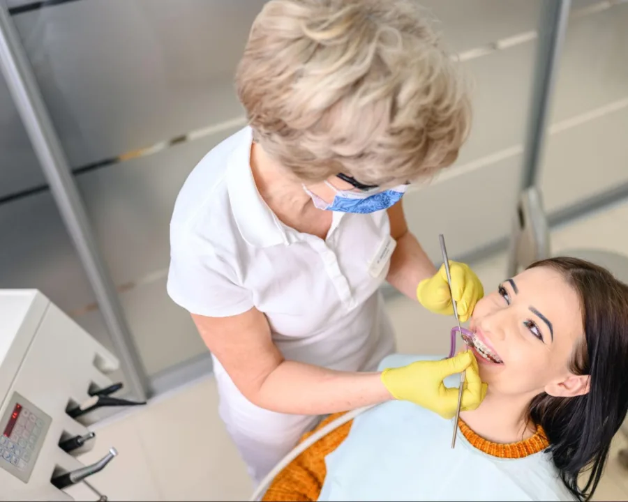 Adult patient getting their braces looked at by the orthodontist.
