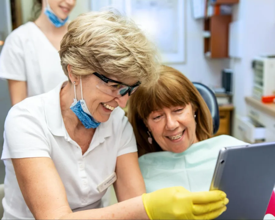 Orthodontist showing an adult patient their braces with a mirror.