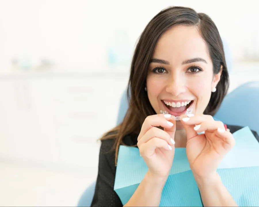 Patient placing clear aligners in their mouth.