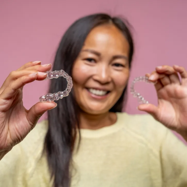 Close-up of invisible aligners for dental correction in a hand.
