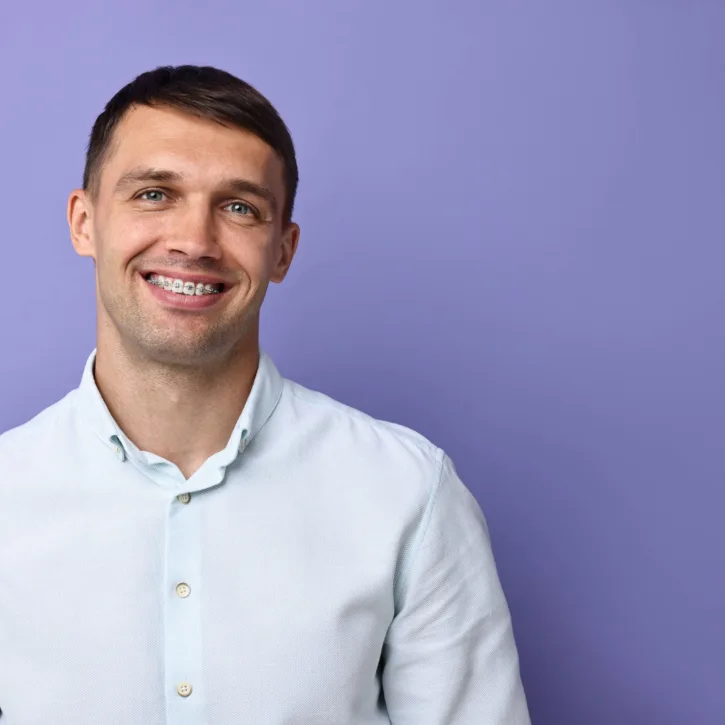 Adult male smiling with metal braces.